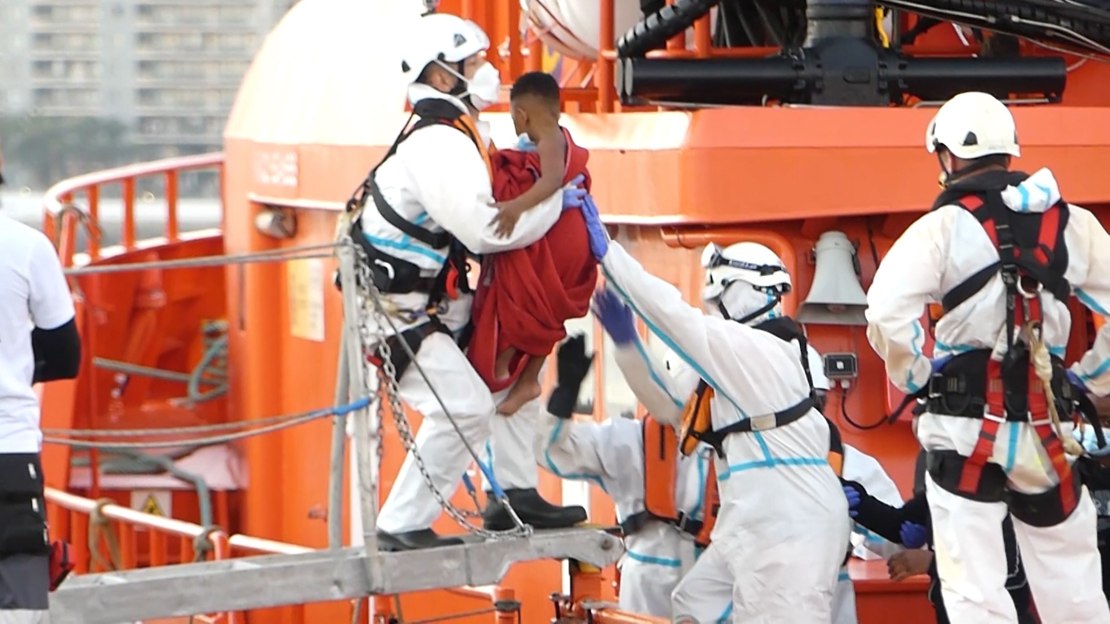 Un miembro de la Cruz Roja ayudaba a bajar del barco a un niño migrante en el puerto de Arguineguín (Gran Canaria, España) el 17 de marzo de 2021. 