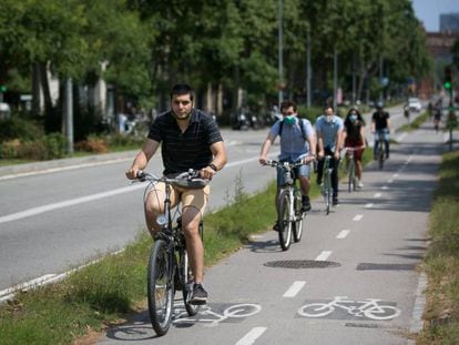 Varias personas se mueven en bicicleta por un carril bici de Barcelona. 
