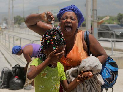 Una mujer auxilia a su hija tras recibir una carga de gas lacrimógeno en Puerto Príncipe (Haití) el 25 de julio 2023.