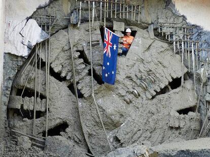 Un operario muestra la bandera de Australia tras el cale de una tuneladora en el trazado de la línea ferroviaria Metronet, en Western Australia.