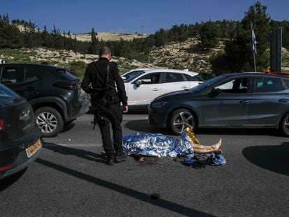 Un policía israelí junto al cuerpo de un atacante palestino tras un ataque en Cisjordania, este jueves.