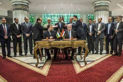 Azzam al-Ahmad (en la mesa, a la derecha), representante de Fatah, y Salah al-Aruri (izquierda), líder de Hamas, firman la reconciliación en el Cairo, este jueves