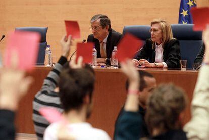 Varios estudiantes muestran tarjetas rojas a Rosa Díez, sentada junto al profesor Rafael Calduch.
