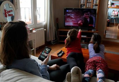 Una familia mira la televisión en Madrid, durante la cuarentena por el coronavirus. 