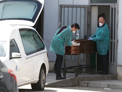 Dos funerarios trasladan un féretro en el hospital Ramón y Cajal.