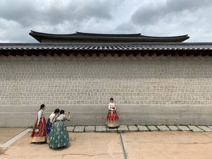 Turistas vestidos con trajes tradicionales coreanos se hacen fotos durante una visita al Palacio Gyeongbokgung de Seoul (Corea del Sur).