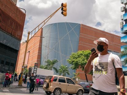 Transeúntes cruzan la calle frente a la esquina emblemática del centro comercial Sambil de La Candelaria en Caracas, Venezuela, el 19 de marzo de 2022.