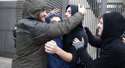 Los amigos de uno de los detenidos le abrazan a la salida de la Ciudad de la Justicia de Valencia.