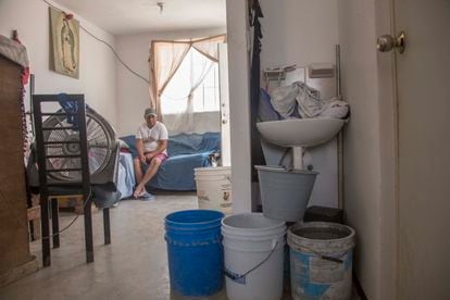 La familia Duque Martínez en el interior de su vivienda muestra los botes con agua que almacena tras la escasez de agua que afecta la zona metropolitana de Monterrey, Nuevo León.