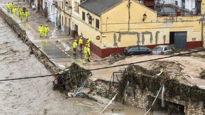 Un grupo de bomberos y personal de los servicios de emergencias trabaja este jueves en Ontinyent (Valencia) ante la crecida de un río. En vídeo, las imágenes de las lluvias torrenciales en Valencia y Albacete.