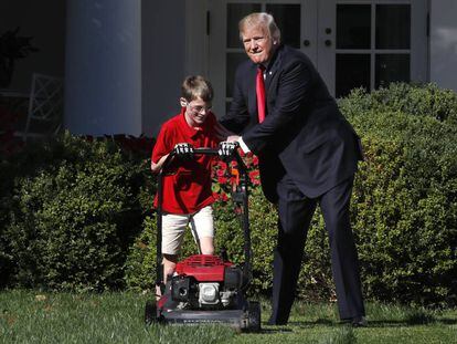 Donald Trump, este viernes en los jardines de la Casa Blanca junto a un ni&ntilde;o que le hab&iacute;a escrito pidi&eacute;ndole cortar el c&eacute;sped.