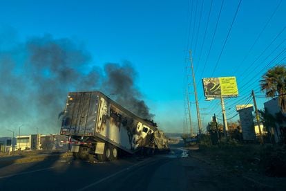 A burning truck is seen across a street during an operation to arrest the son of Joaquin "El Chapo" Guzman, Ovidio Guzman, in Culiacan, Sinaloa state, Mexico, on January 5, 2023. - Intense shootings and burning of vehicles were reported Thursday in the Mexican city of Culiacan (northwest) after an operation in which Ovidio Guzman, son of imprisoned drug trafficker Joaqu�n "El Chapo" Guzman, was arrested, Mexican authorities said. (Photo by Marcos Vizcarra / AFP)