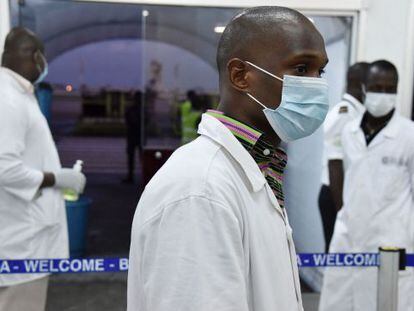 Personal sanitario espera para hacer controles a pasajeros en Costa de Marfil. 