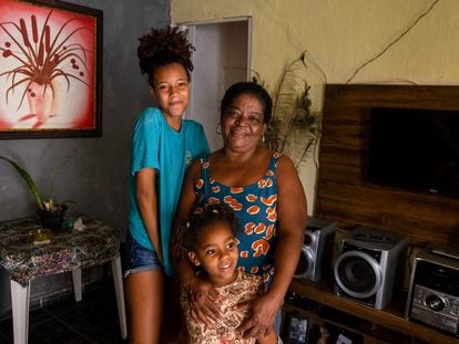 Edeleusa Pereira, beneficiaria de la paga contra la pobreza Auxilio Brasil,  acompañada de sus nietas en Salvador de Bahía el pasado martes.