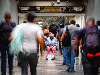 Una mujer de la tercera edad pide limosna en el metro de Ciudad de México.