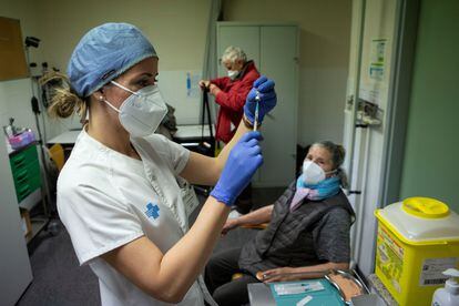 Una enfermera se dispone a inyectar la primera dosis de la vacuna contra la covid a una anciana en Barcelona, el 3 de marzo.