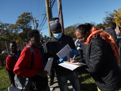 Migrantes senegalíes llenan un formulario afuera de un albergue en Queens, Nueva York.