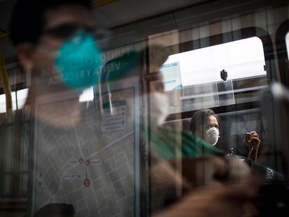 Viajeros que llevan máscaras protectoras como precaución contra la propagación del nuevo virus corona, viajan en un autobús público en Lima, Perú.