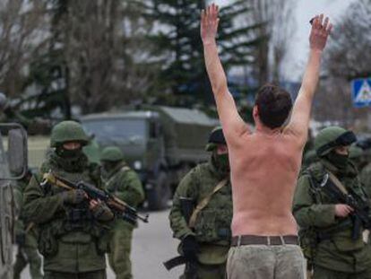 Un hombre ucranio protesta frente a soldados sin identificar y que hacen guardia en Balaklava, a las afueras de Sebastopol, en Ucrania. 