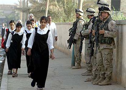 Un grupo de niñas se dirige al colegio en Bagdad ante la vigilancia de soldados de EE UU.

 / REUTERS