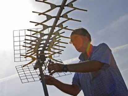 Un técnico instalando una antena de televisión.