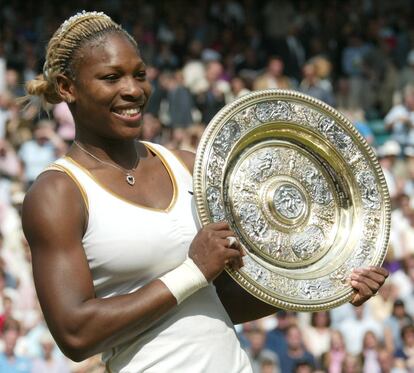 Serena Williams, ganadora de la final individual femenina del torneo de Wimbledon 2002, sujeta el trofeo, después de vencer a su hermana Venus en la final.