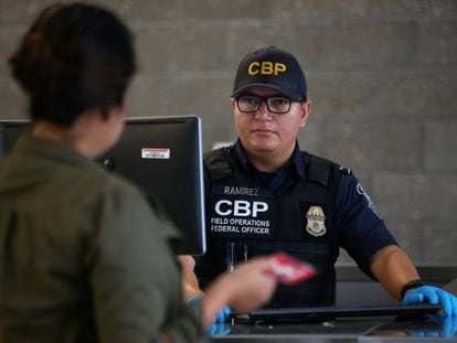 Un agente de migración entrevista a una visitante en California.