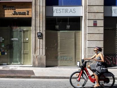 Una dona passa davant de comerços tancats a Barcelona.