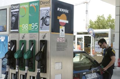 Un joven pone gasolina a su coche en una gasolinera. 