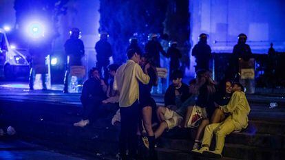 Jóvenes en las escaleras de la plaza de Espanya mientras la Guardia Urbana desaloja la zona en la última madrugada de las fiestas de La Mercè.