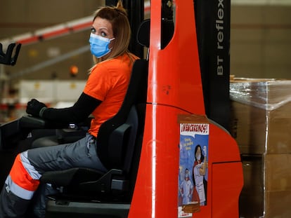 Una trabajadora con mascarilla en una empresa logística.