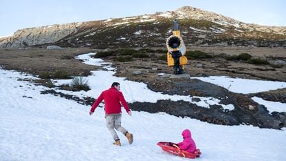 Javier Simón juega con su hija, junto a un cañón de nieve en Alto Campoó (Cantabria), el 22 de enero de 2024.