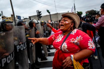 A woman confronts police officers deployed to control a demonstration in downtown Lima on July 19.