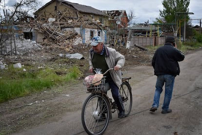 Un residente en la región de Zaporiyia, se mueve con su bici entre los restaurantes de casas dañadas tras un ataque ruso el 10 de mayo.