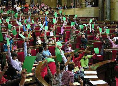 Niños de primaria, en el momento de una votación en el Parlamento catalán.
