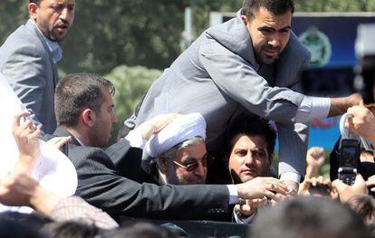 Rohaní, rodeado de sus guardaespaldas a la llegada a Irán.