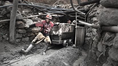 El minero Nelson Espinoza, de 33 años, arrastra un vagón junto a otros compañeros a la salida de un túnel de la mina.