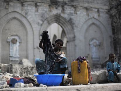 Una mujer lava la ropa sentada entre las ruinas de una antigua catedral católica en Mogadiscio (Somalia), al huir de su casa por la peor sequía de los últimos 60 años en el Cuerno de África.