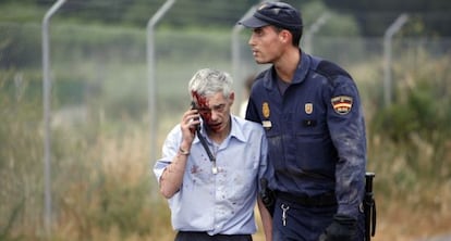 Un policía acompaña al maquinista Francisco José Garzón, poco después del accidente del tren Alvia.