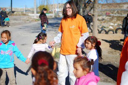 Una voluntaria de ArcelorMittal juega con los niños del Gallinero, la zona más pobre y deteriorada del poblado chabolista de la Cañada Real.