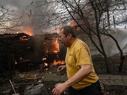 Yevghen Zbormyrsky, 49, runs in front of his burning house after being shelled in the city of Irpin, outside Kyiv, on March 4, 2022. - More than 1.2 million people have fled Ukraine into neighbouring countries since Russia launched its full-scale invasion on February 24, United Nations figures showed on March 4, 2022. (Photo by Aris Messinis / AFP)