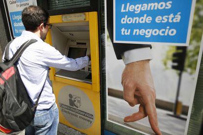 Un usuario retirando efectivo de un cajero de CaixaBank en Madrid.