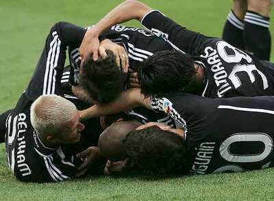 Los madridistas se abrazan sobre el césped a Roberto Carlos tras su gol decisivo.