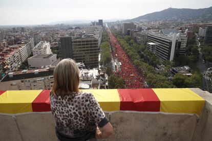 Una mujer observa desde un balcón la manifestación independentista.