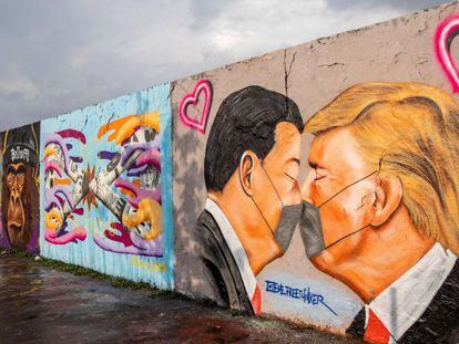 Vista de un mural del presidente estadounidense Donald Trump (D) y el presidente chino Xi Jinping besándose usando mascarillas en el Parque del Muro de Berlín.