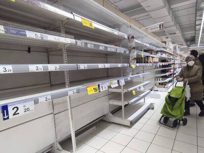 Una mujer observa unas estanterías vacías de legumbres en un supermercado de Madrid. 