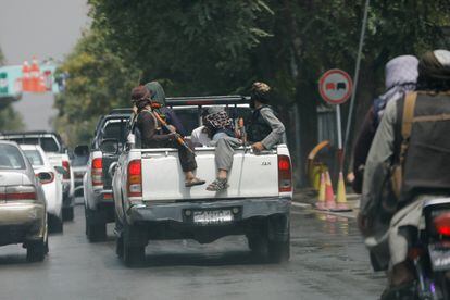 Combatientes talibanes llevan a un hombre detenido en un automóvil militar en Kabul.

