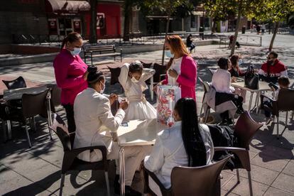 Una familia celebra separada en varias mesas una comunión en el bar La Ardilla, el sábado, en Villa de Vallecas. 