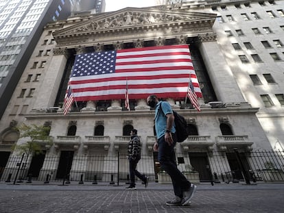 Dos personas pasan este viernes frente a la Bolsa de Nueva York.