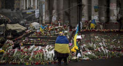 Una mujer con una bandera de Ucrania en un memorial en la Plaza de la Independencia de Kiev.